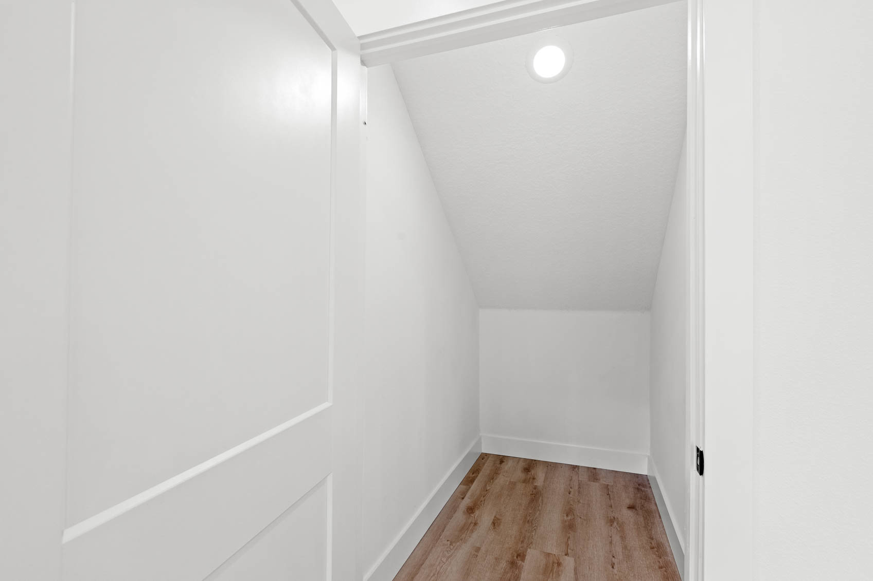 storage room with white walls and wooden floors